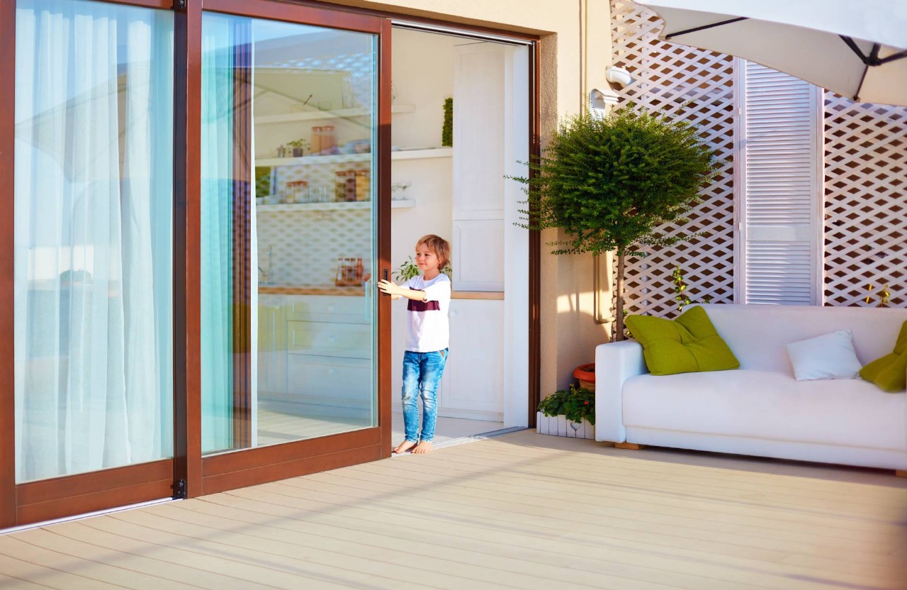 A child pulling a sliding glass door closed at The Shade Shop near Grand Rapids, MI